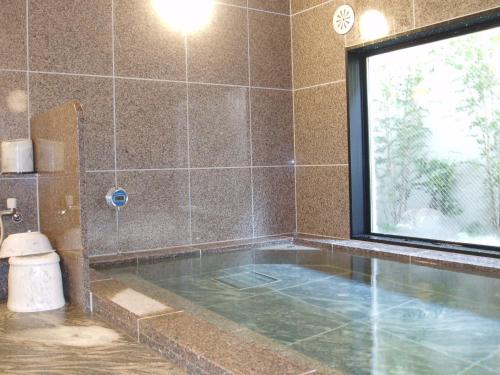y baño con bañera, ventana y aseo. en Hotel Route-Inn Sagamihara -Kokudo 129 Gou-, en Sagamihara