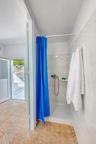 a bathroom with a shower with a blue shower curtain at Veranda Syros House in Ermoupoli