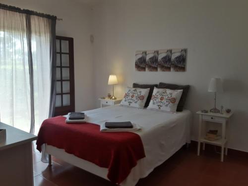 Un dormitorio con una cama grande con una manta roja. en Alsouk, en Vilamoura