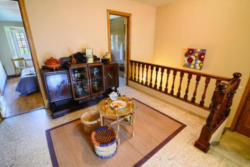a living room with a table and a staircase at La Casa Antollosdocesar in Baralla