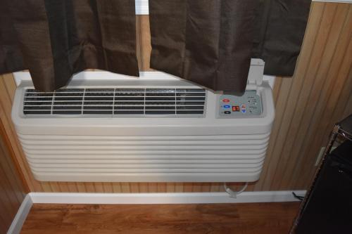 a white air conditioner sitting under a window at Gorgeous View Motel in Watkins Glen