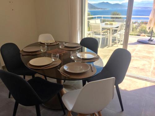 a dining room with a table and chairs and a balcony at Les Villas MarInCelu in Porto Pollo