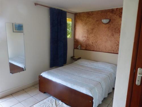Dormitorio pequeño con cama y espejo en Airport hotel en Ducos