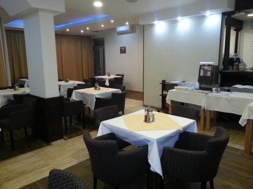 un comedor con mesas y sillas con mantel blanco en Hotel Viv, en Trebinje