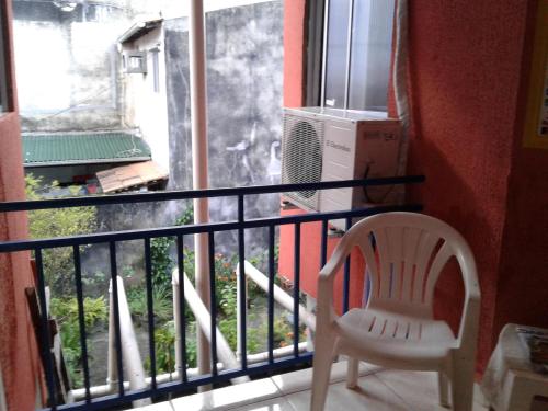 a white chair sitting on a balcony next to a window at Pousada da Didi in Belém