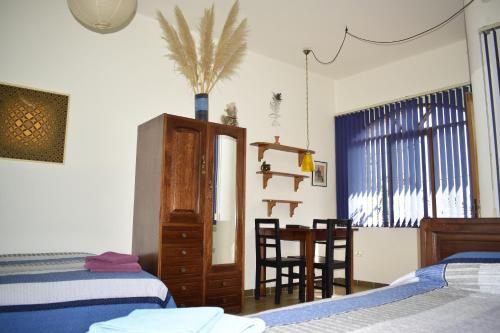 a bedroom with two beds and a table and chairs at Bella Vista El Tronco in Sucre
