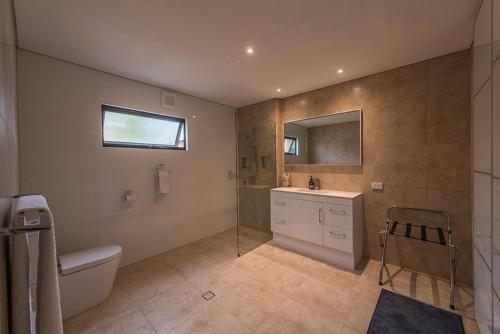 a bathroom with a toilet and a sink and a mirror at Beach House Dunsborough in Dunsborough