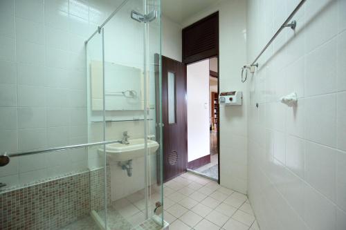 ein Bad mit einer Glasdusche und einem Waschbecken in der Unterkunft View Hostel in Hualien