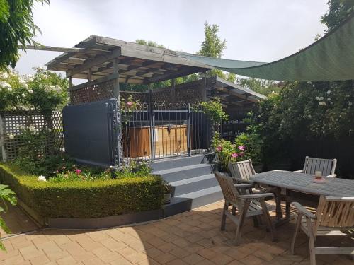 a patio with a table and chairs and a fence at Olde Mill House B&B & Bike2Wine cycle hire in Renwick