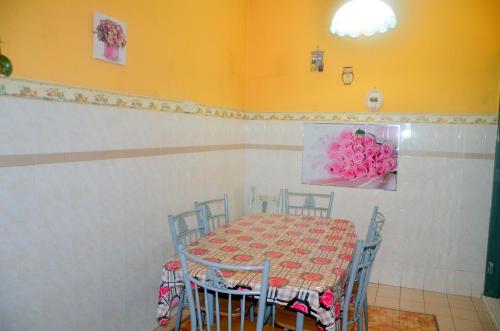 a dining room with a table and chairs with pink flowers on the wall at Homestay Mamasya Melaka in Melaka