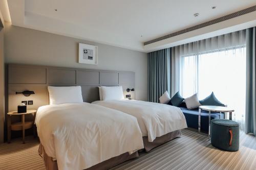a hotel room with a large bed and a window at Greet Inn in Kaohsiung