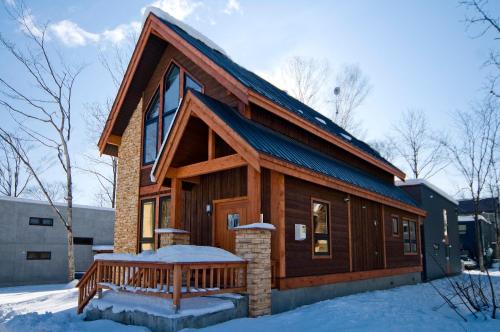 a log cabin with a porch in the snow at Gouka Chalet in Kutchan