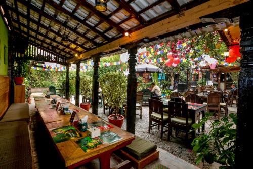 um restaurante com mesas e cadeiras e uma pérgola em Hotel Himalayan Oasis em Catmandu