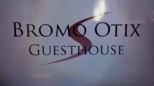 a window with the words brono otitis guest house at Bromo Otix Guest House in Bromo