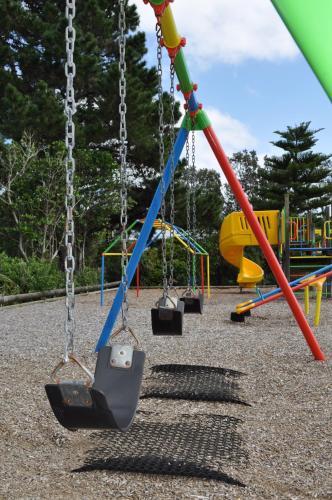 a group of swings in a playground at Urenui Beach Camp in Urenui