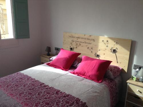 1 dormitorio con 1 cama con 2 almohadas rosas en Apoteka apartaments, en Figueres