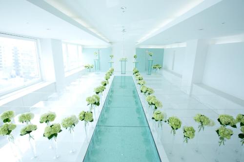 a white room with a row of green plants at Art Hotel Hirosaki City in Hirosaki