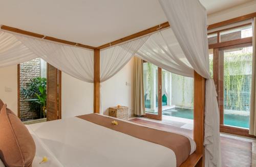 1 dormitorio con 1 cama con dosel en Villa Beji, en Seminyak