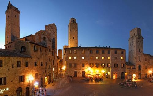 a view of a city with towers at night at Leon Bianco in San Gimignano