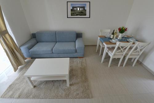 a living room with a blue couch and a table at Apartmany Dolni Dunajovice in Dolní Dunajovice