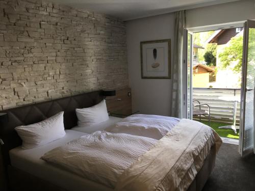 a bedroom with a bed and a brick wall at Hotel Almrausch in Bad Reichenhall