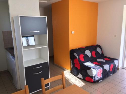 a room with a chair and a book shelf at Camping Pyrénées Nature in Oloron-Sainte-Marie