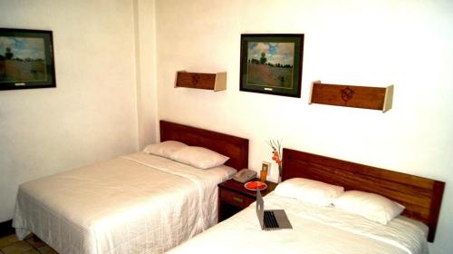 a hotel room with two beds and a table at Hotel Premier Saltillo Coahuila in Saltillo