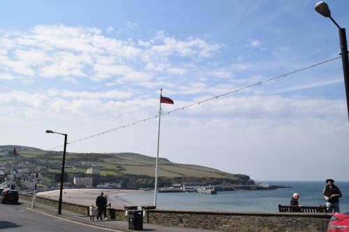a person standing on a pier next to a body of water at Kittiwake House in Port Erin