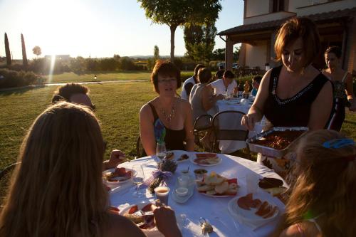 a group of people sitting at a table eating food at Agriturismo Le Rondini Di Francesco Di Assisi in Cannara