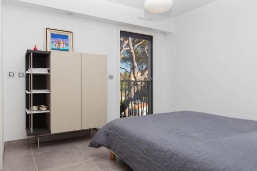 サントロペにあるAppartement centre St Tropezのベッドルーム1室(ベッド1台付)、スライド式ガラスドアが備わります。