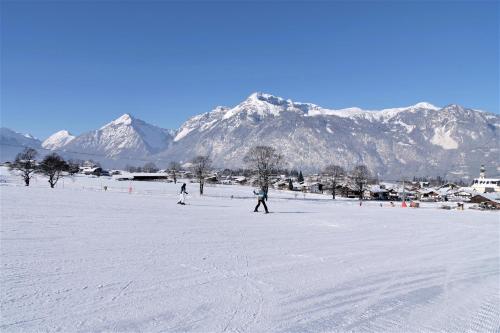 two people skiing in the snow with mountains in the background at Angerer Alpine Suiten und Familienappartements Tirol in Reith im Alpbachtal