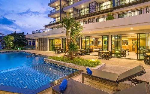 an exterior view of a building with a swimming pool at AVA SEA Resort Krabi, Ao Nang Beach in Ao Nang Beach