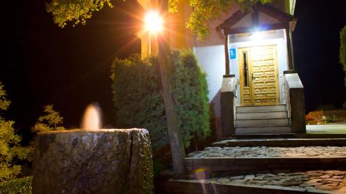 a small house with a yellow door at night at Hospedium Hostal Restaurante El Mirador de Atienza in Atienza
