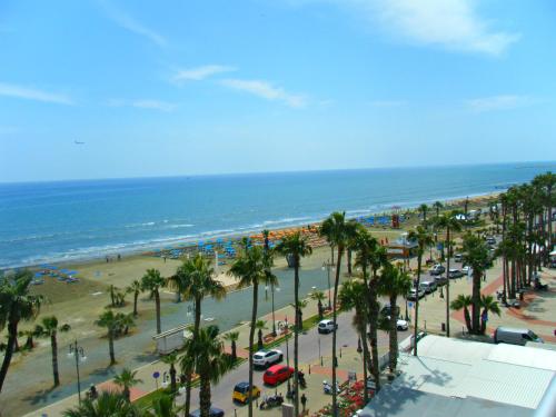 a view of a beach with palm trees and the ocean at Periyiali Beach Sunset Suite A7 in Pervolia
