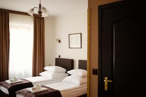 um quarto de hotel com duas camas e uma janela em Hotel Eden em Cracóvia