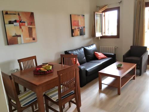 a living room with a table and a couch at Apartamento Valle Golf Resort in Baños y Mendigo