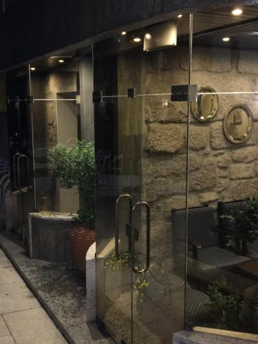 a glass entrance to a building at night at Hotel Central Jardim in Geres