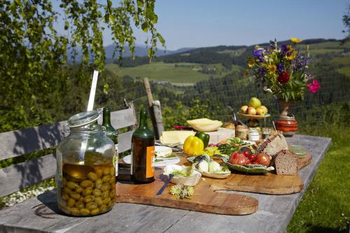 a picnic table with food and a bottle of wine at Biolandhaus Arche in Eberstein