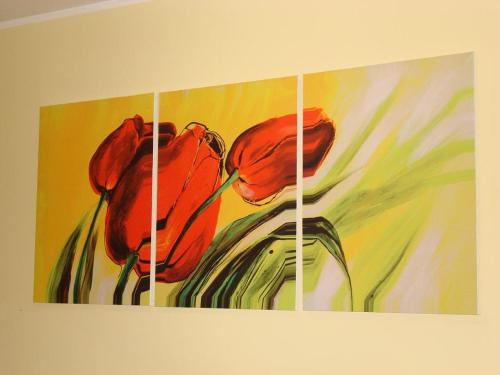 a painting of two red flowers on a wall at B&B Il Gabbiano in Reggio Calabria