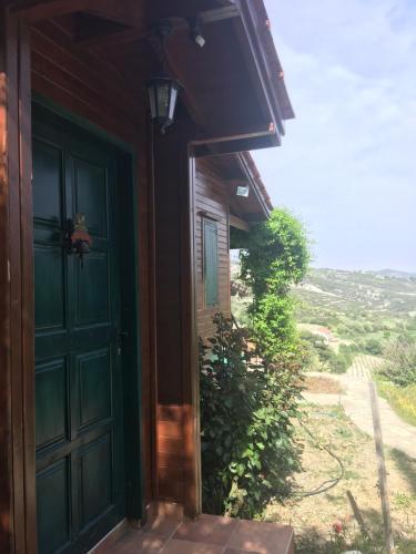 a green door on the side of a house at Koilani Village House in Koilani