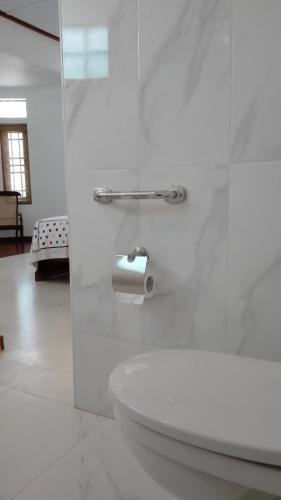 a white bathroom with a sink and a toilet paper roll at Crescent N Cocoon in Ambalangoda