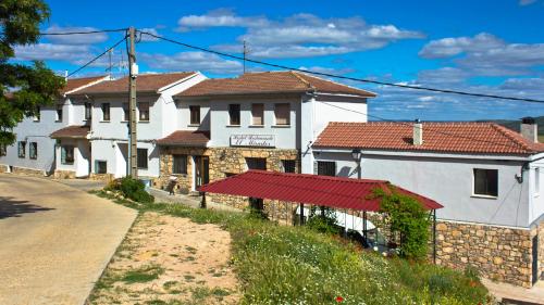 a row of white buildings with a red roof at Hospedium Hostal Restaurante El Mirador de Atienza in Atienza