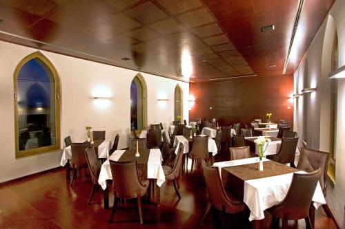 Ladanjsko Imanje Principovac في إيلوك: غرفة طعام مع طاولات وكراسي مع قماش الطاولة البيضاء