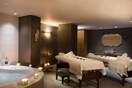 a spa room with two beds and a bathtub at U Boutique Kinneret by the Sea of Galilee in Tiberias