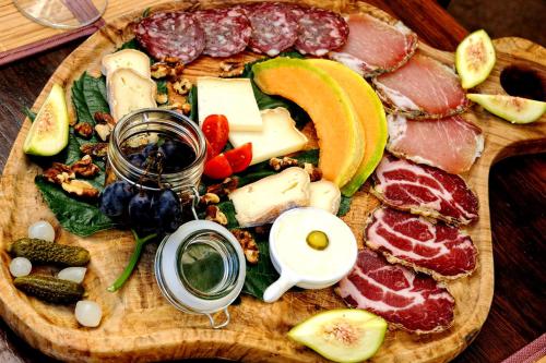 a plate of food with meats and vegetables on a cutting board at A Sulana Chambre d'hôtes in Valle-di-Campoloro