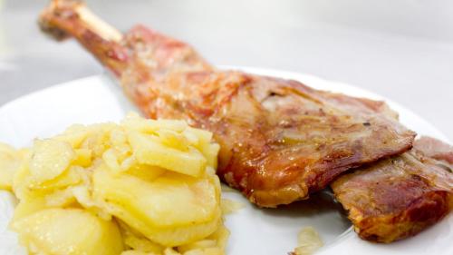 a plate of food with meat and potatoes on it at Hospedium Hostal Restaurante El Mirador de Atienza in Atienza