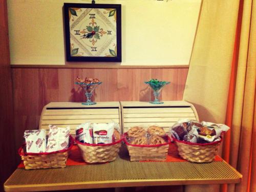 ein Tisch mit Körben voller Essen darauf und eine Uhr in der Unterkunft San Nicolò House in Aci Catena