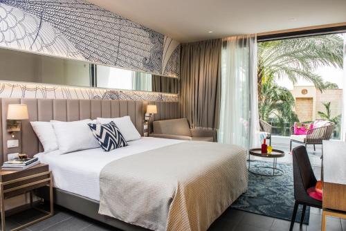 a hotel room with a bed and a balcony at U Boutique Kinneret by the Sea of Galilee in Tiberias