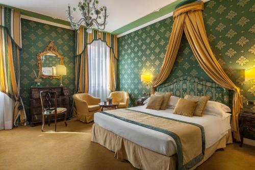a bedroom with a large bed with green wallpaper at Hotel Ca' dei Conti in Venice