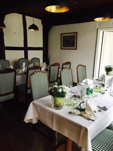 a dining room with tables and chairs with flowers on them at Landhotel Gutshof im Oertzetal in Oldendorf, Südheide in Hermannsburg